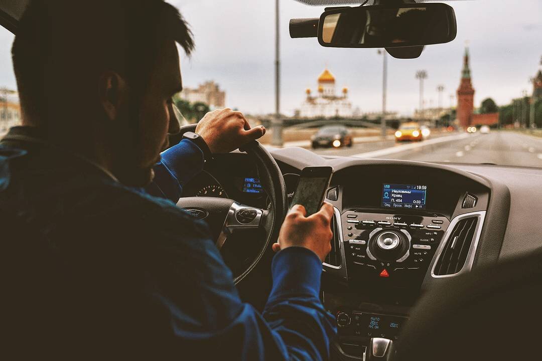 На фото мы видим молодого человека ведущим машину, знаем марку машины, какая песня воспроизведена, в каком городе он едет, что он делает с телефоном, сколько времени.