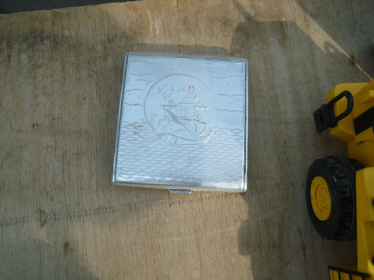 Обычный портсигар. Но что нацарапано на нем красным? Инициалы бывшего хозяина?