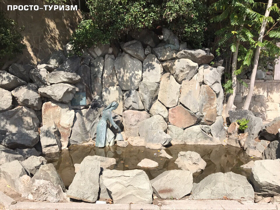 Арзы с кувшином у фонтана, а сверху из-за камней за ней следит Али-Баба.