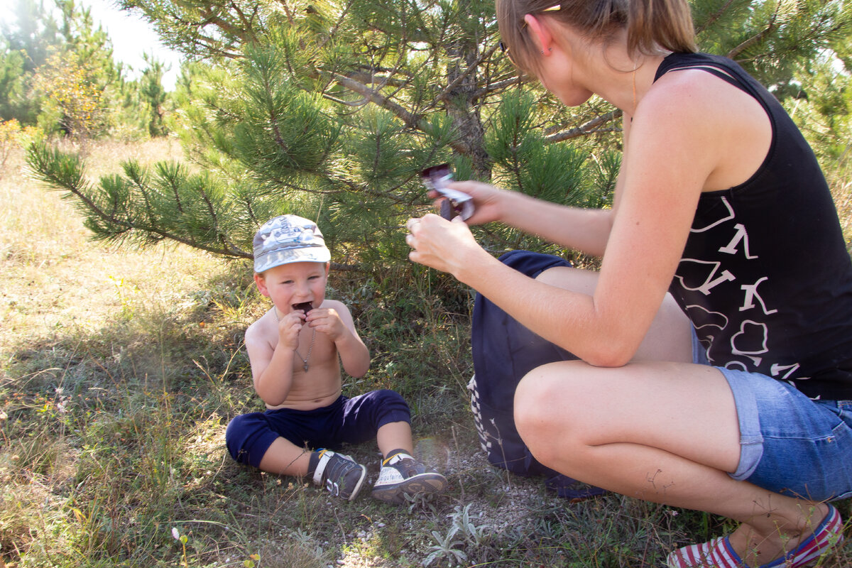 Саша в походе кушает шоколадку, чтобы восстановить силы)