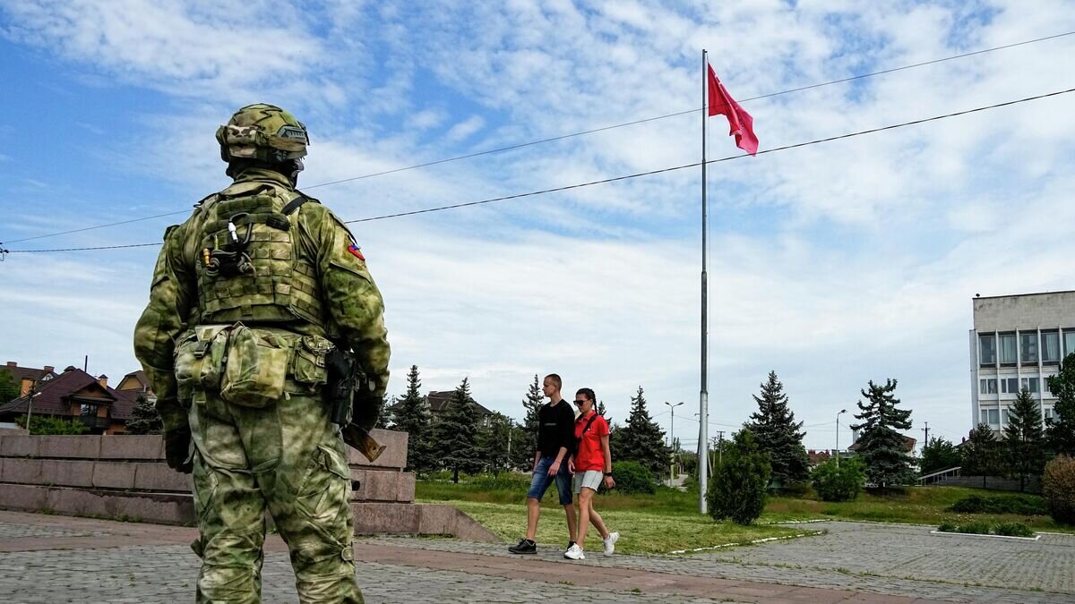    Военнослужащий и местные жители в Херсоне© AP Photo
