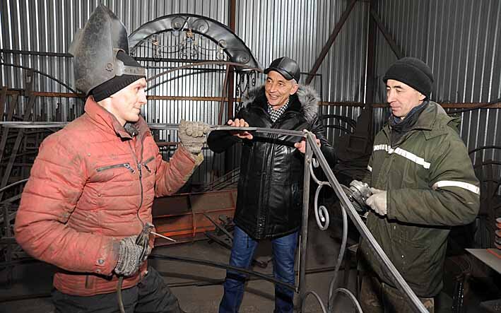 Рабочее место у Рависа (в центре) не только в теплом офисе, но и в производственном ангаре.