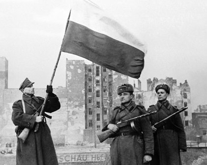 17 января 1945 года, Варшава, польский солдат с бело-красным флагом и двумя советскими солдатами, фото: East News