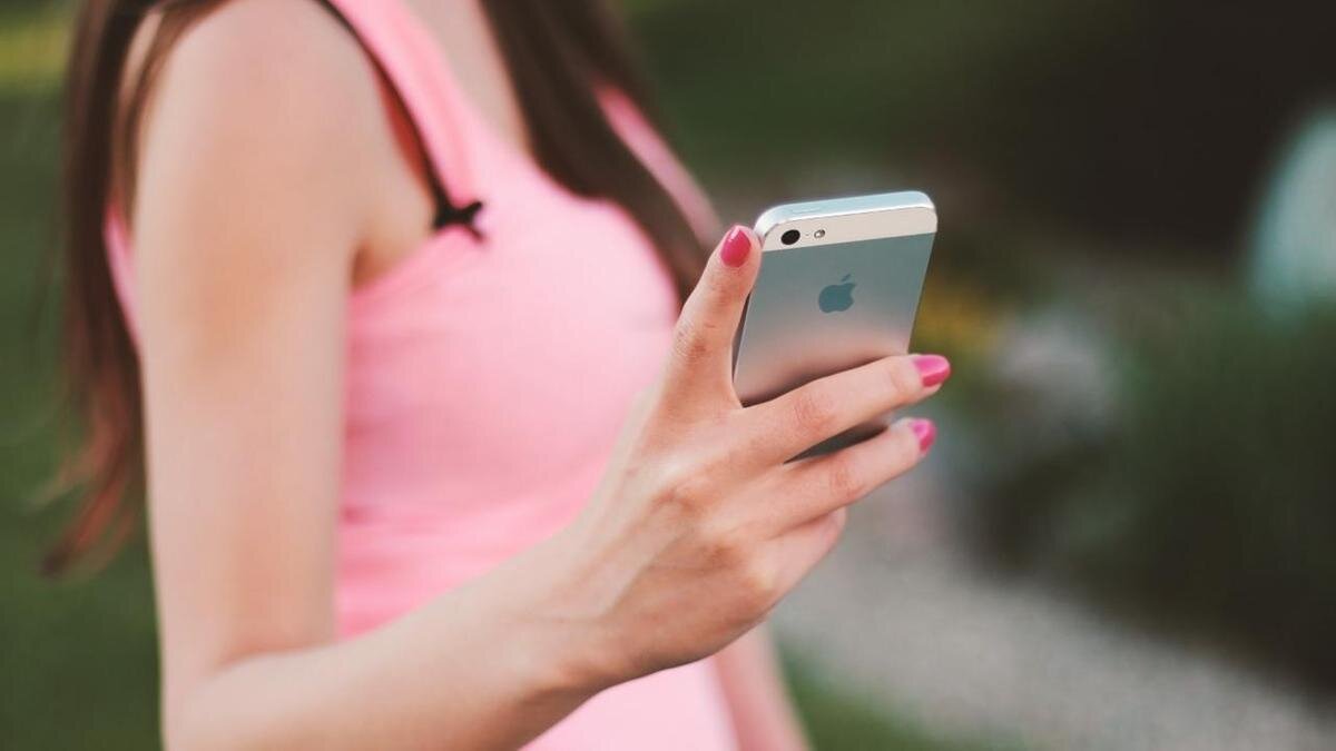    Девушка в розовой майке держит смартфон:Pixabay.com