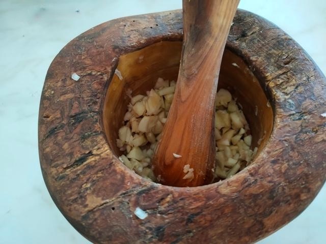 Раздавить в ступке зубчики чеснока.