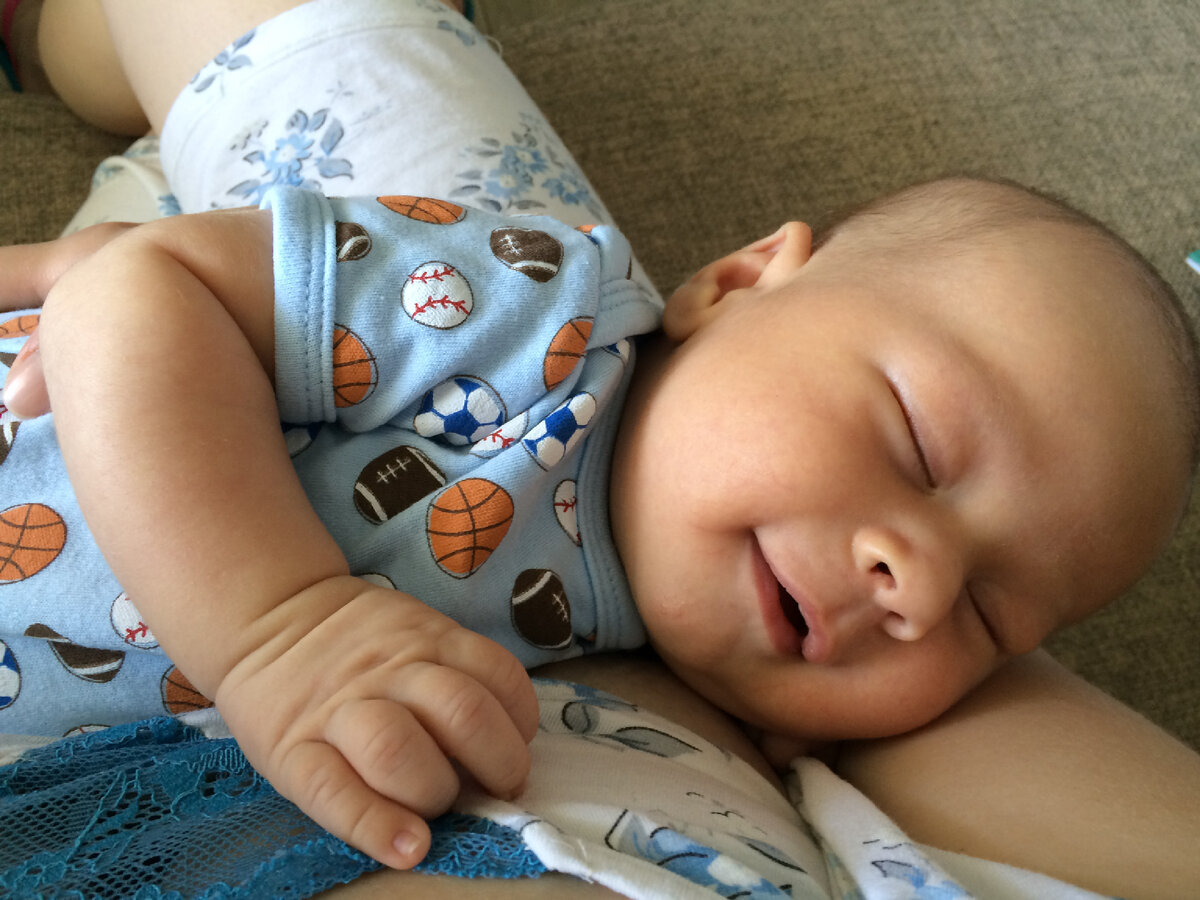 Наш второй сын, улыбается во сне, когда заснул у меня на руках 