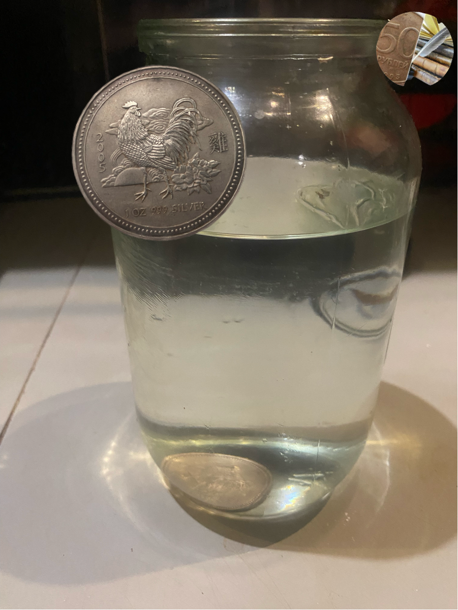 Серебряная монета в банке с питьевой водой.