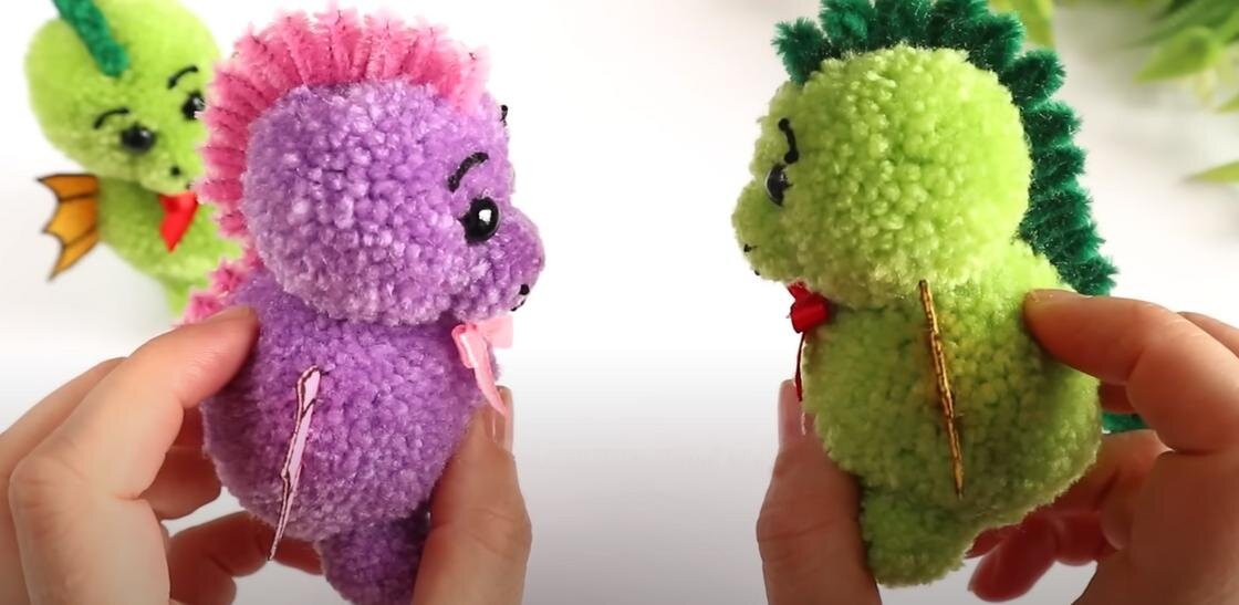    В руках игрушка дракончик из пряжи:YouTube / MARLENA-Hand Made