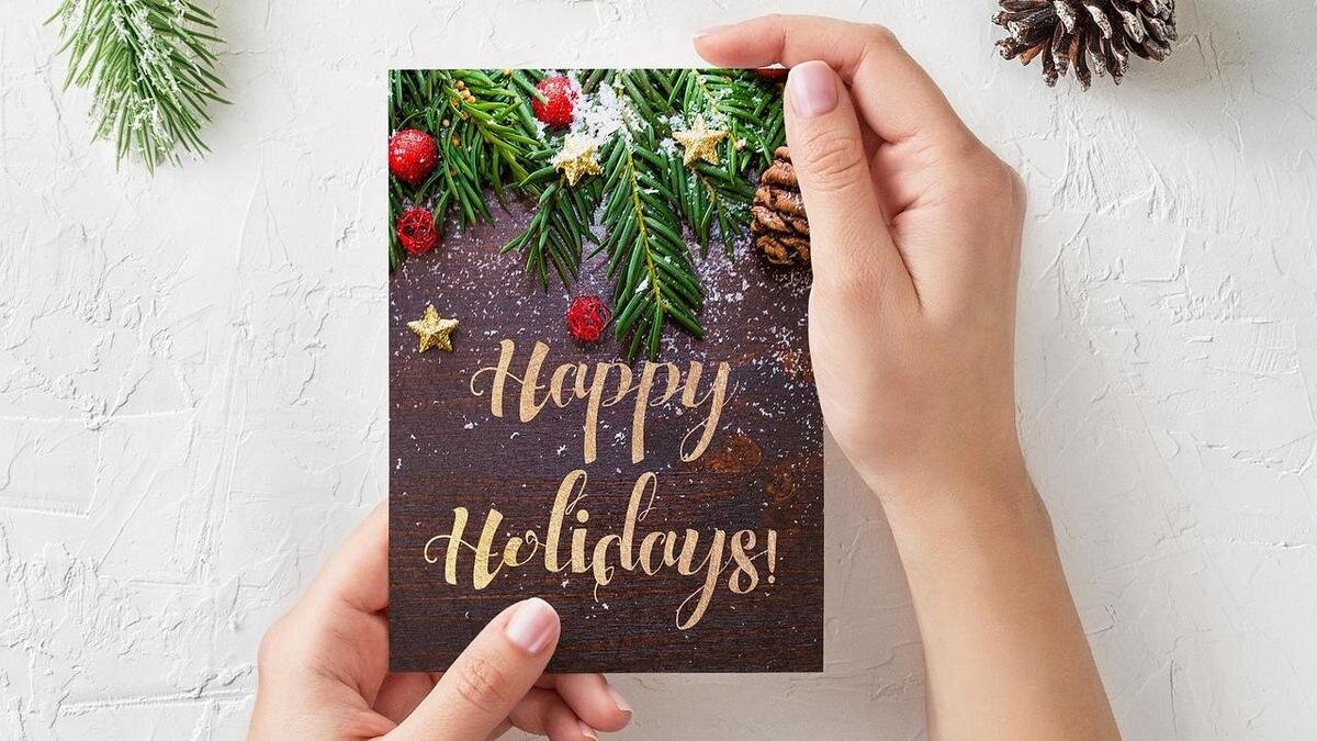    Женские руки держат новогоднюю открытку с изображением еловых веток:Pixabay