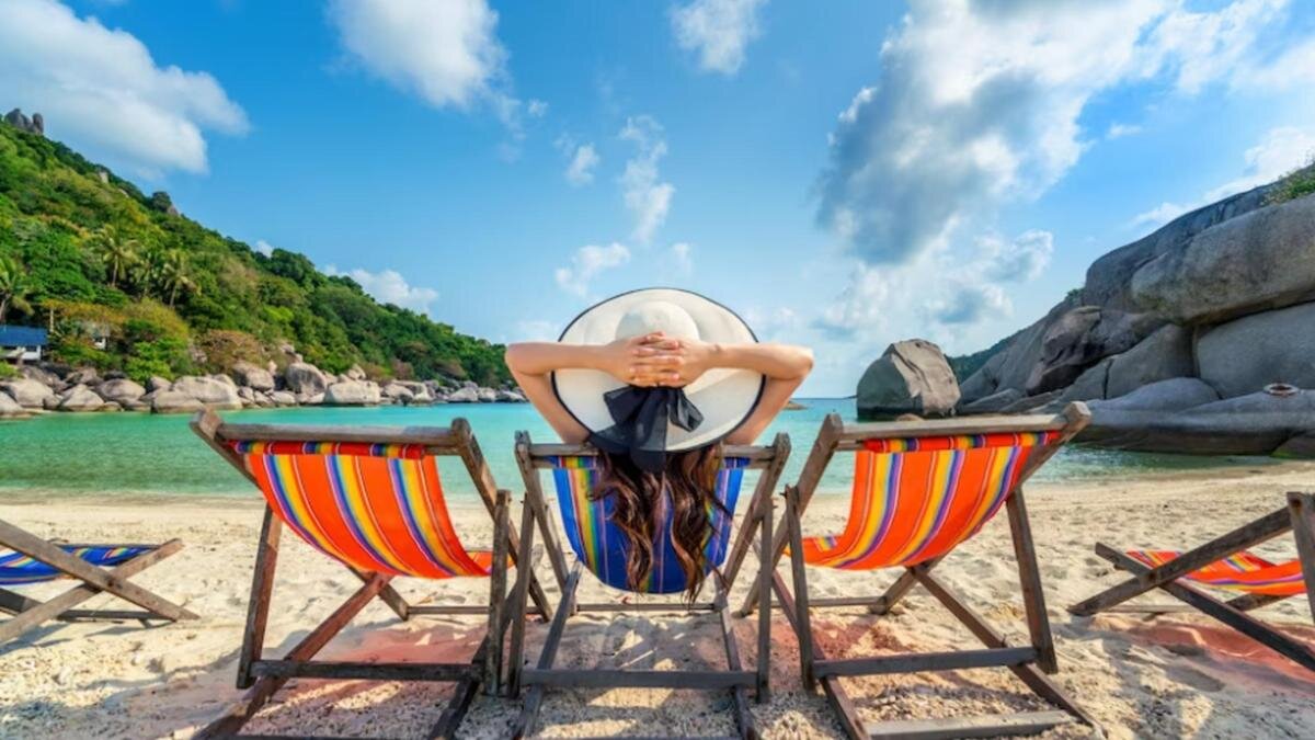   Девушка сидит в шезлонге на берегу водоема:Freepik