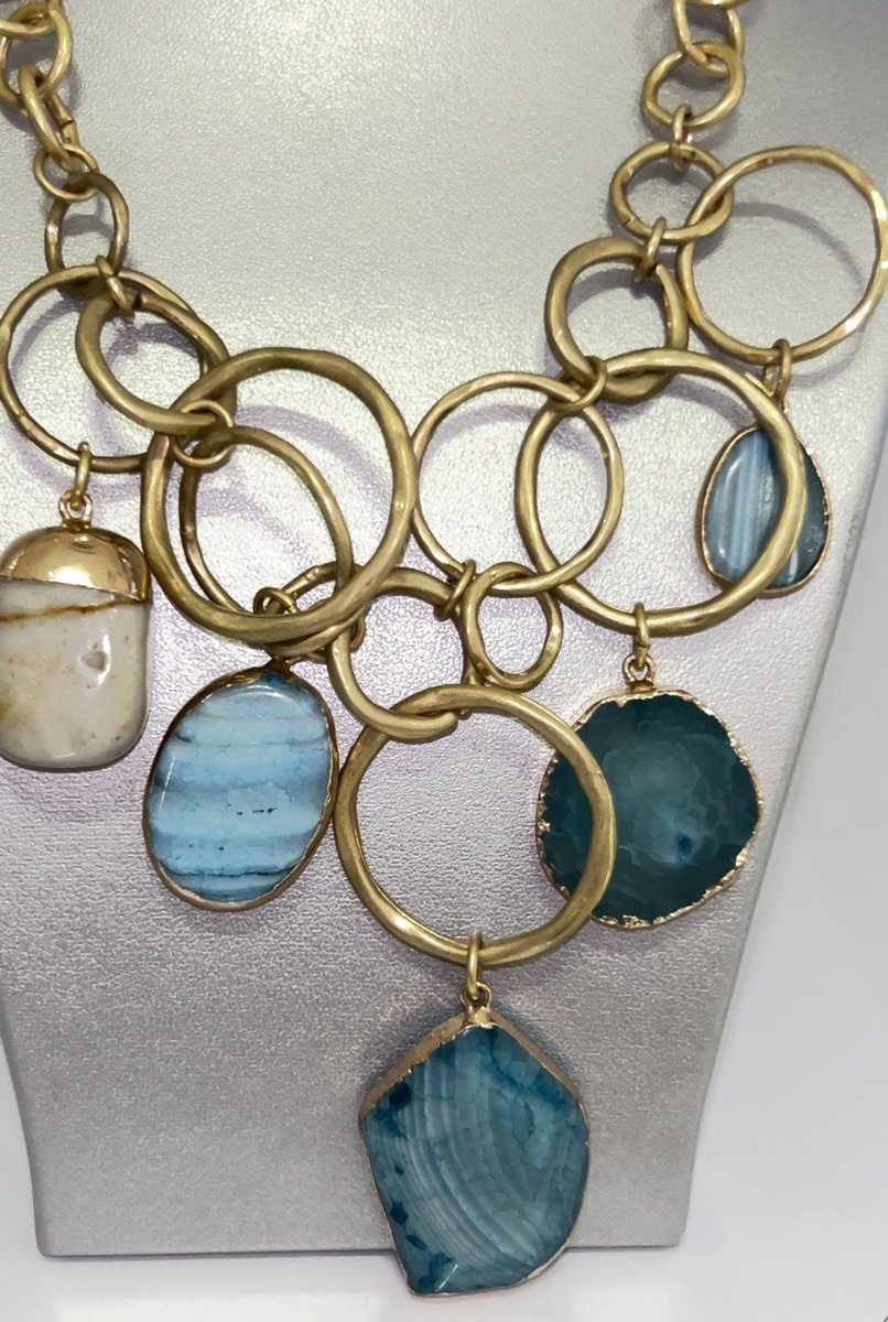 Массивное колье,которое отлично будет сочетаться с предложенным Look, а серьги пусеты в позолоте закончат ваш образ