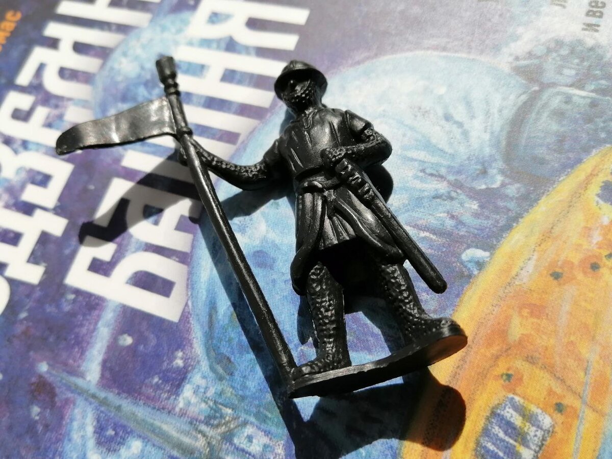 Фигурка средневекового стража на фоне книги "Подземная башня" (2022)