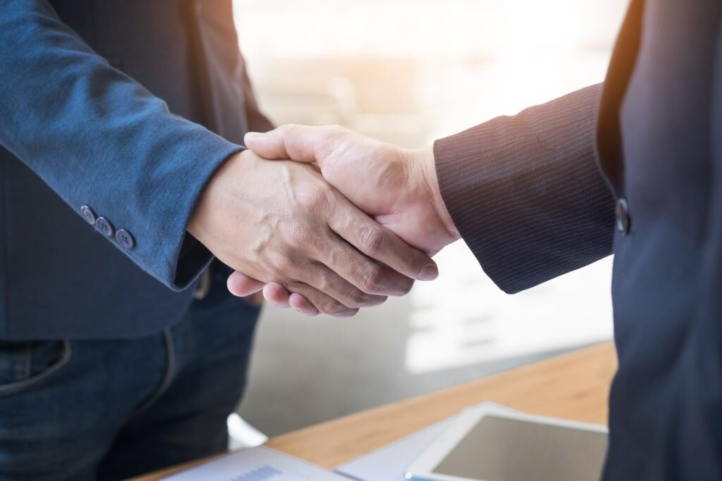    Two confident business man shaking hands during a meeting in the office, success, dealing, greeting and partner concept GxP News