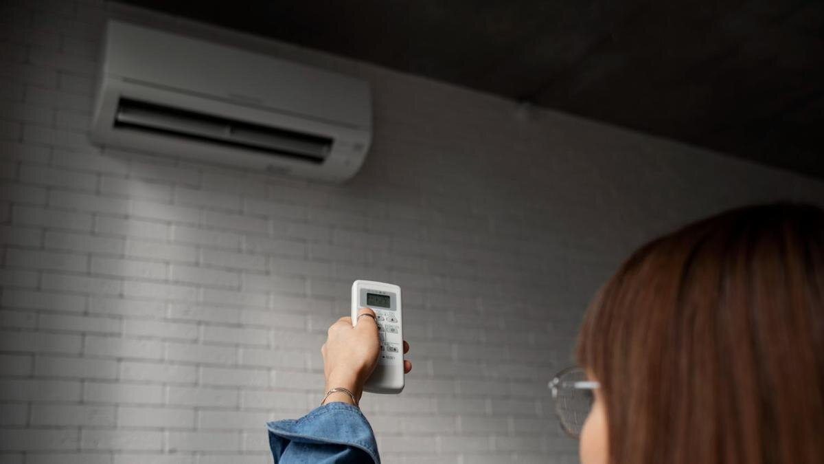    Девушка включает кондиционер:Freepik