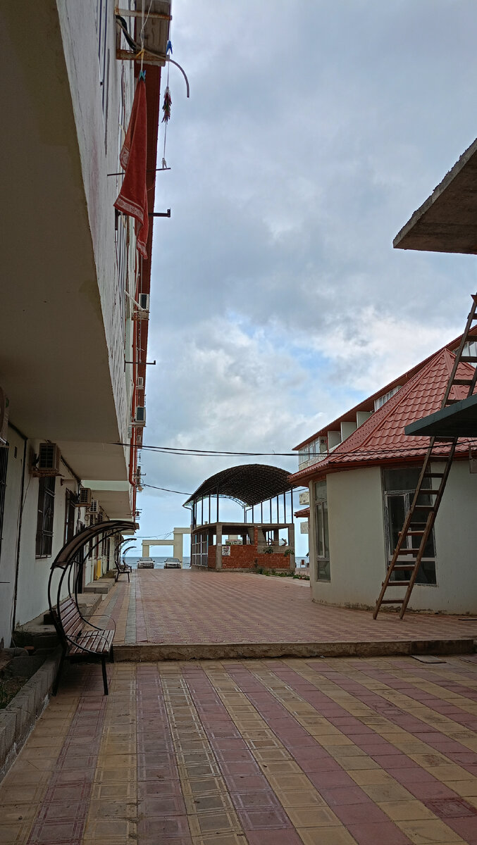 Двор, где мы жили эти дни. Как видите, море совсем рядом. Недостроенное здание - это будующий магазин, а под Красной крышей -это мечеть