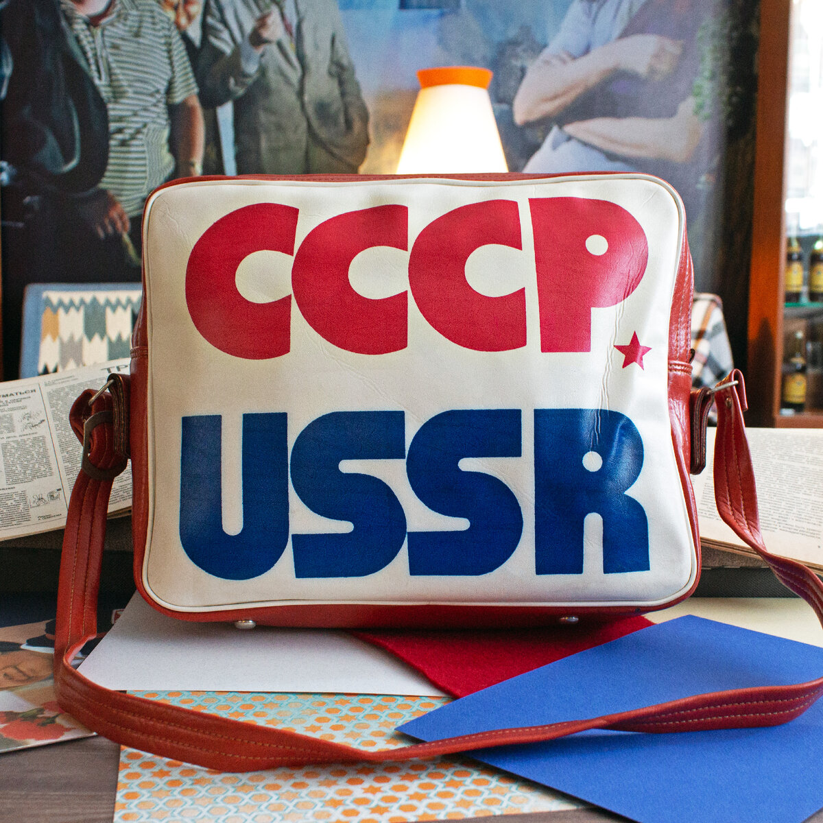 Советская эпоха, эта удивительная и противоречивая страница в истории нашей страны, навсегда вписала свои уникальные символы в общекультурный контекст. Один из таких символов — сумка-портфель СССР, аксессуар, который воплощает в себе дух тех времен, отражает стремление к практичности, функциональности и лаконичности в дизайне. Сумка-портфель СССР появилась в период советской эпохи и стала активно использоваться в повседневной жизни широкого круга людей. Ее популярность была настолько велика, что она перестала быть просто удобным аксессуаром для переноски документов и превратилась в символ времени. Дизайн этого портфеля был отличительным и запоминающимся. Конструкция сумки-портфеля СССР была простой, но элегантной. Строгие линии, практичность и функциональность делали его неотъемлемым спутником студентов, рабочих и государственных служащих. Казалось, что каждый его элемент говорит о том, как важен порядок и удобство в повседневной жизни советского человека. Этот аксессуар был тщательно выполнен из высококачественной, крепкой кожи или надежного кожзаменителя, что обеспечивало его долговечность и сохранность внешнего вида на протяжении многих лет активного использования. Одним из интересных дизайнерских решений сумки-портфеля СССР были внутренние карманы красного цвета. Красные боковые кармашки, несмотря на свои скромные размеры, идеально подходили для хранения карт, пропусков и прочих мелочей. Красный цвет карманов как будто подчеркивал связь с эпохой, придавал яркость и узнаваемость. Сумка-портфель оснащалась удобной ручкой и регулируемым плечевым ремнем, благодаря чему её можно было комфортно носить как в руке, так и на плече. Эти элементы обеспечивали легкость и удобство переноски портфеля, позволяя пользователю выбирать наиболее удобный для него способ носки. Сумка-портфель СССР служила не просто удобным аксессуаром для повседневной жизни, но и стала отражением советского образа жизни, символизировала стремление к практичности и функциональности. Теперь сумка-портфель СССР является объектом коллекционирования и находит отклик среди энтузиастов советской истории. Этот предмет не только напоминает о прошлых временах, но и представляет собой уникальный символ советской эпохи.