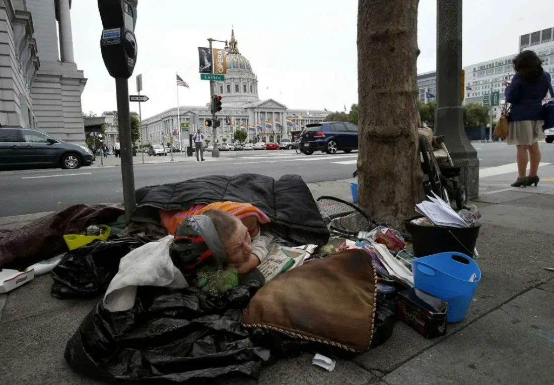 Блеск и нищета капитализма, в прямом смысле - бездомные бродяги на фоне роскошного здания оперы, у которого останавливаются лимузины с мужчинами во фраках и женщинах в вечерних платья