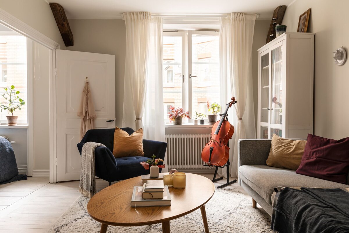 Экскурсию по квартире предлагаю начать с гостиной (необычную кухню оставим на десерт). Здесь живет семья музыкантов — ей 29 лет, ему 38 лет. Она работает в филармонии, он — выступает на частных мероприятиях. Эту двушку площадью 40 квадратов супруги купили в ипотеку 5 лет назад