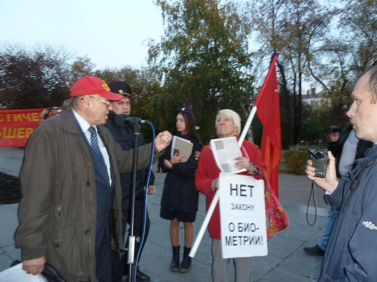 Полиция обступила микрофон со всех сторон (справа тоже полицейский в штатском), из коммунистов в кадре только А.К. Черепанов (у микрофона) и В.Н. Минина