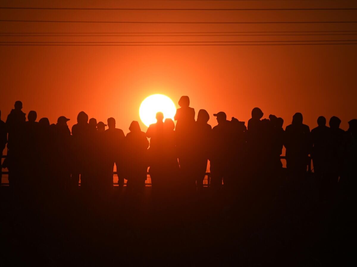    Люди стоят во время заката© РИА Новости / Алексей Мальгавко