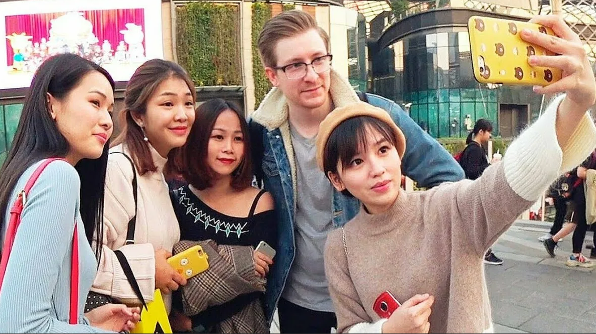 Девушки японки фотографируются с высоким блондином, ничего необычного в Японии