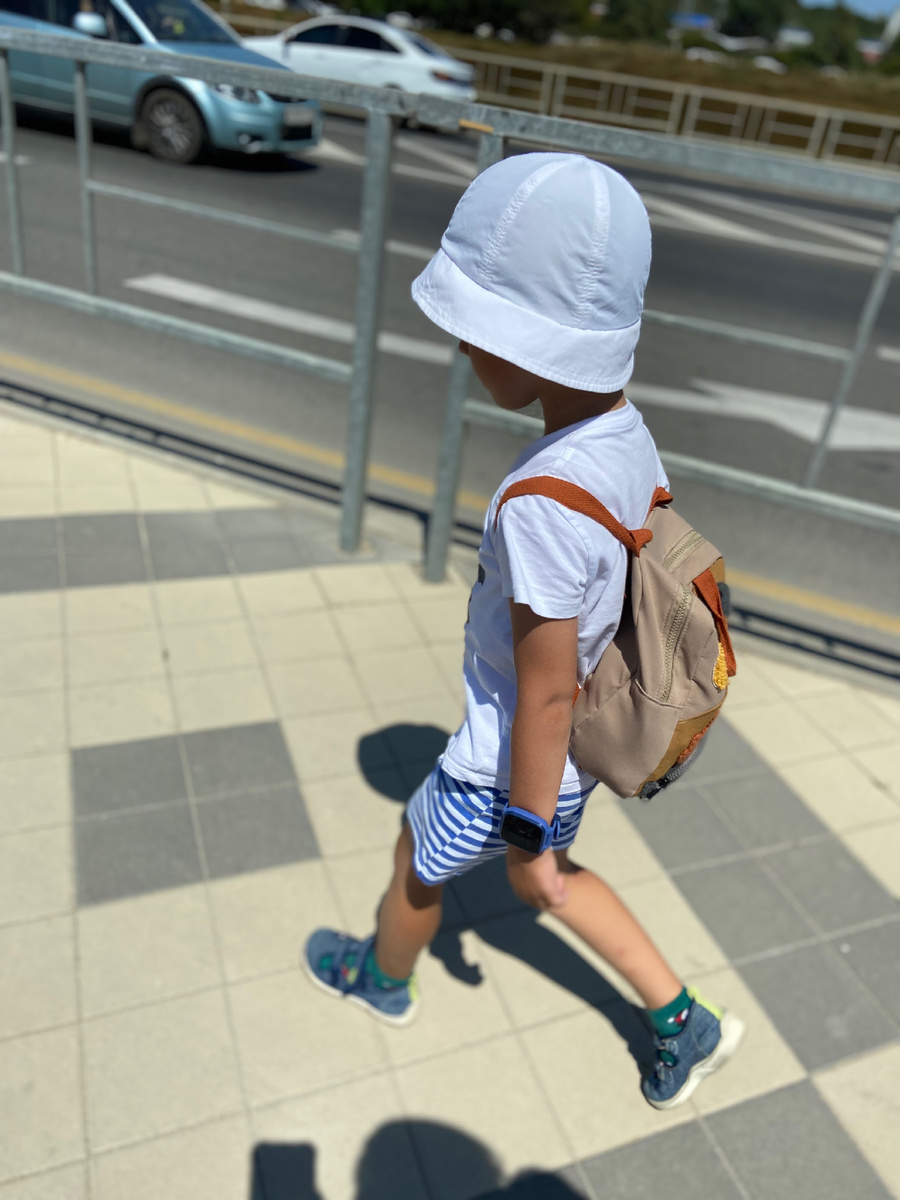 Тифлокомментарий. Ребенок шагает по тротуару. Личное фото автора.