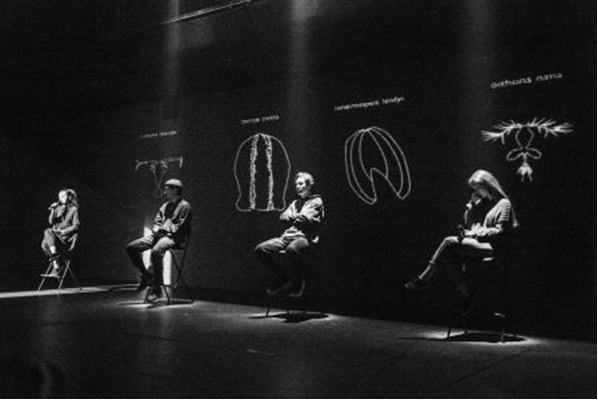 Сцена из спектакля «Копеподы.Путь.Исследование». Часть первая «Копеподы». Позади говорящих проекция вида планктона, который представляет каждый артист, и его научное название. Фото Екатерина Краева.