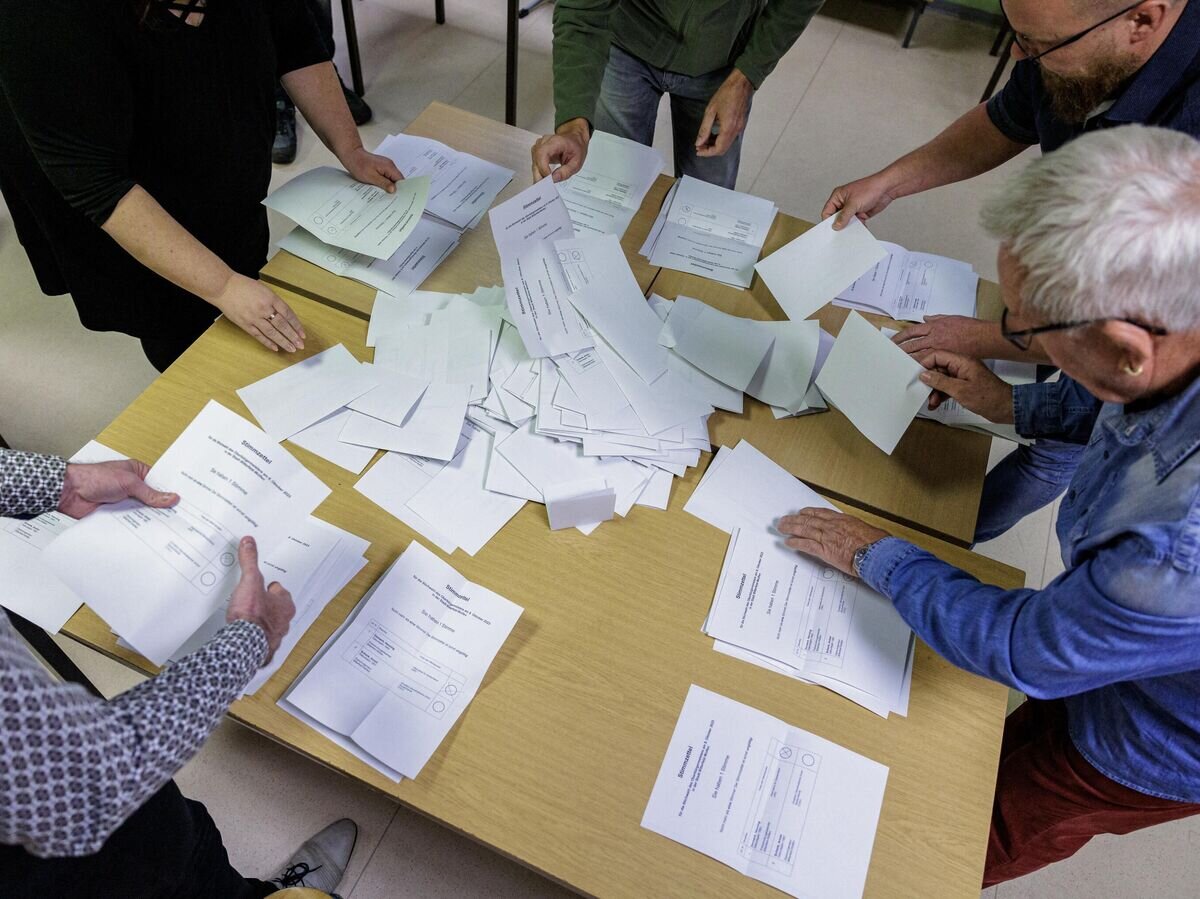    Сотрудники избирательной комиссии подсчитывают голоса во втором туре выборов в региональные парламенты© AFP 2023 / JENS SCHLUETER