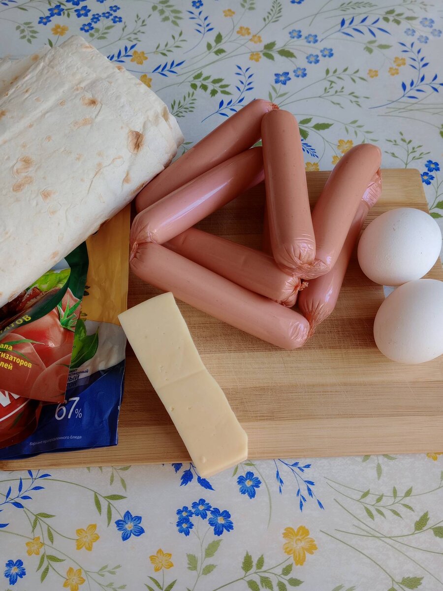 Продукты: 1.	Сосиски – 1 упаковка.
2.	Лаваш тонкий – 2 штуки.
3.	Сыр – 200 грамм.
4.	Майонез – 2 ст. ложки.
5.	Кетчуп – 2 ст. ложка.
6.	Яйцо – 2 штуки.
7.	Масло – для жарки.
