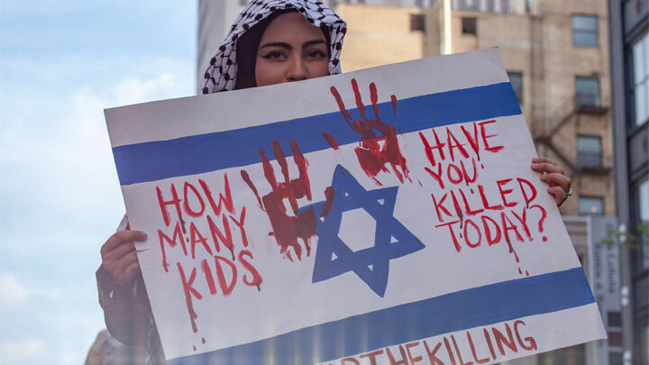 НАДПИСЬ НА ПЛАКАТЕ: "CКОЛЬКО ДЕТЕЙ ТЫ УБИЛ СЕГОДНЯ". ФОТО: STEPHEN ZENNER/GLОBALLООKPRЕSS