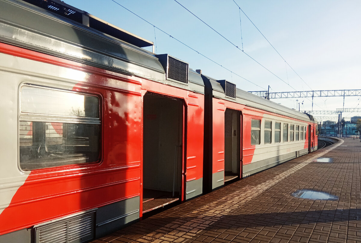 Чуть-чуть меняем ракурс, и солнце отражается в одном из окон электропоезда, а луж, тем временем. на платформе оказывается немного так больше одной. И они они, лужи-то, явно оттаяли к восьми утра, хотя ночью были легкие заморозки!