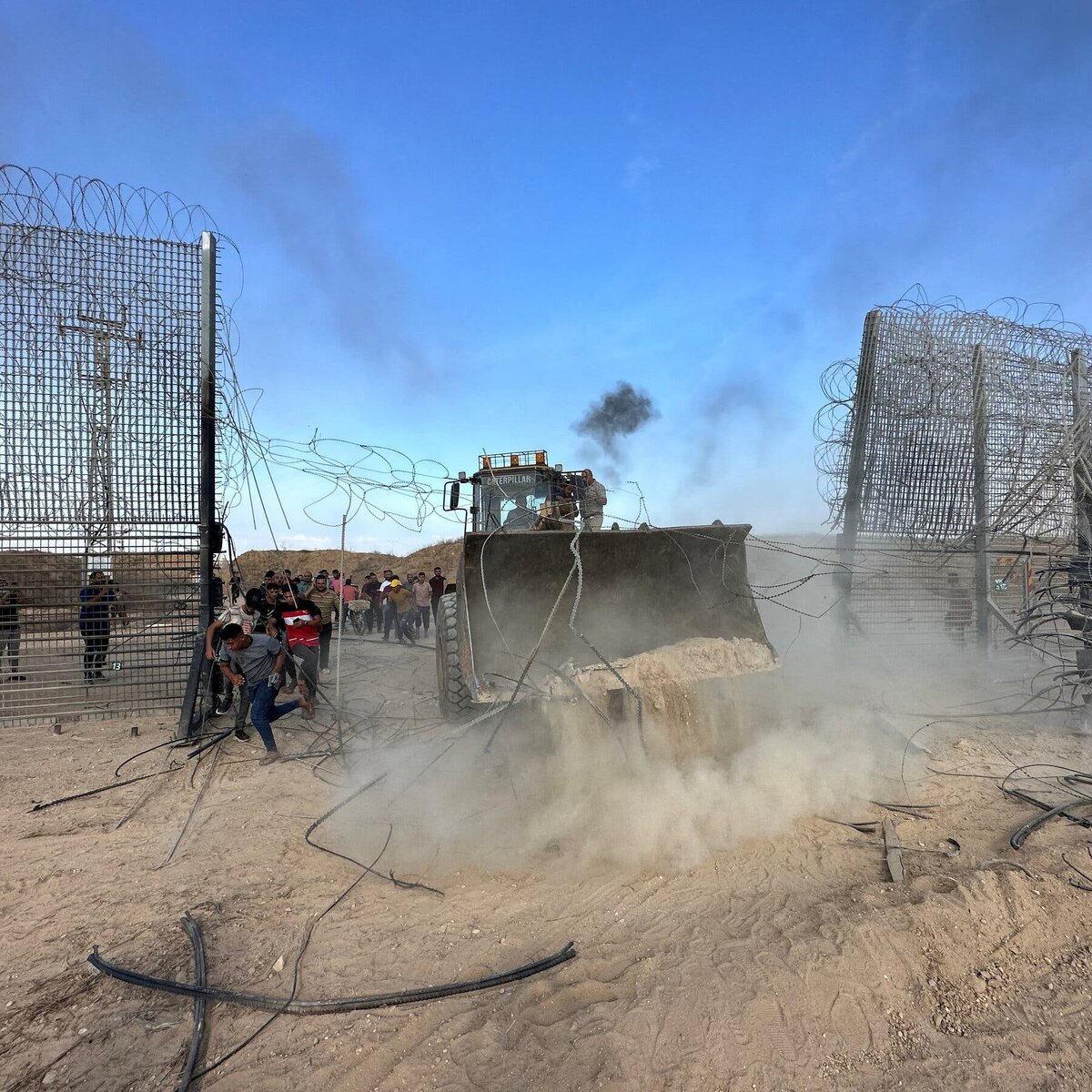 Герои ХАМАСА использовали землеройную технику, чтобы прорвать пограничный забор между Газой и Израилем в субботу, что позволило более чем 1500 бойцам прорваться почти через 30 пунктов вдоль границы. Фото: Мохаммед Файк Абу Мостафа / Reuters.