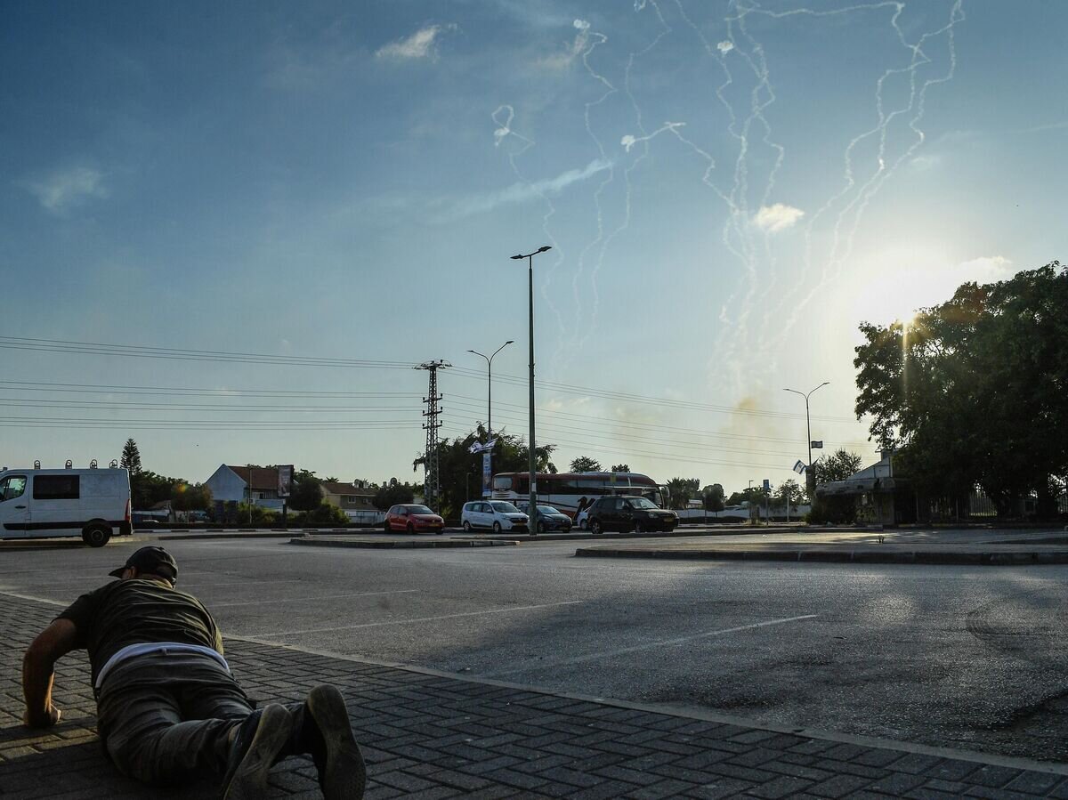    Мужчина лег на землю на улице в Ашкелоне во время обстрела города группировкой ХАМАС© РИА Новости / Стрингер