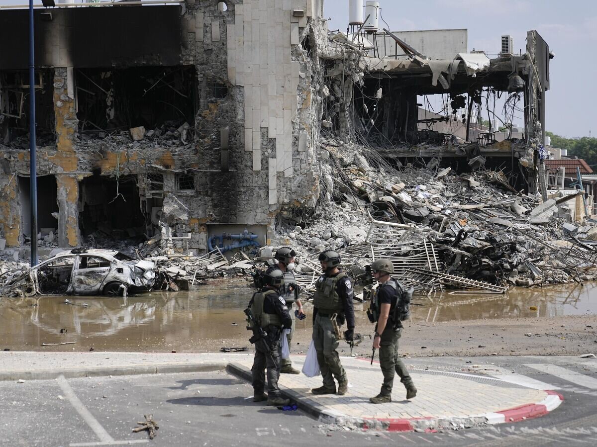    Израильские полицейские на фоне разрушенного здания в Сдероте© AP Photo / Ohad Zwigenberg