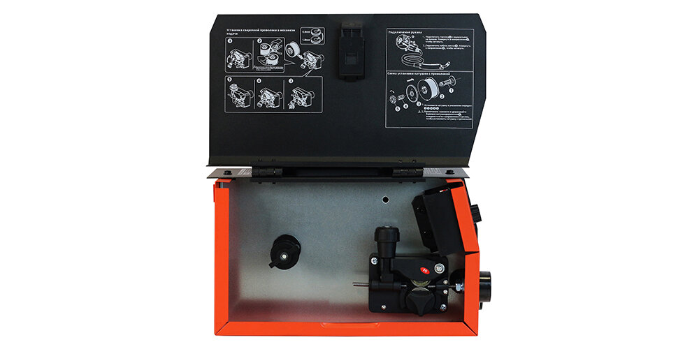 Под "капотом" у сварочного инверторного аппарата грамотно выполенный механизм протяжки установки и протяжки проволоки. На крышке изнутри указана графическая инструкция как установить проволоку в аппарат, а затем протянуть в механизм.