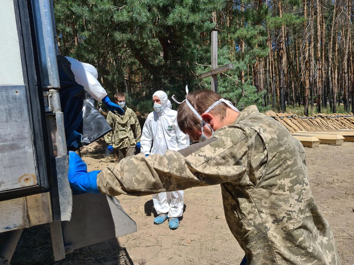    Украинские военнослужащие помогают хоронить своих сослуживцев в Старобельске© РИА Новости / Олеся Потапова