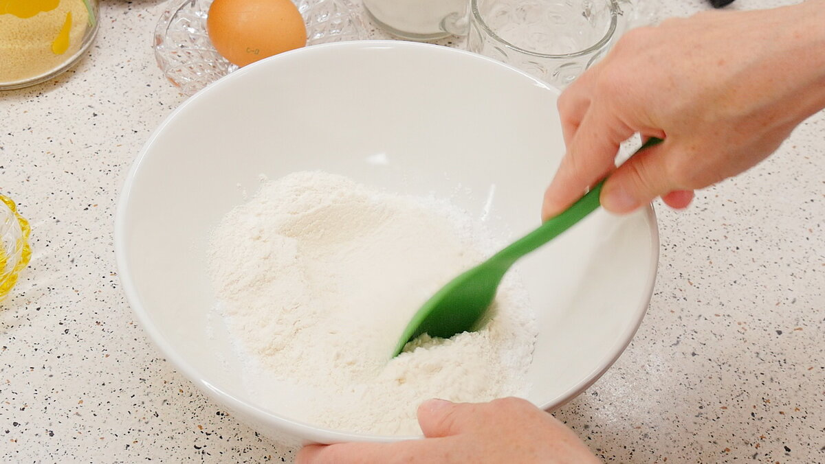 В одной миске смешиваем 1 стакан муки, 2 столовые ложки сахара, 2 чайные ложки разрыхлителя и щепотку соли. 