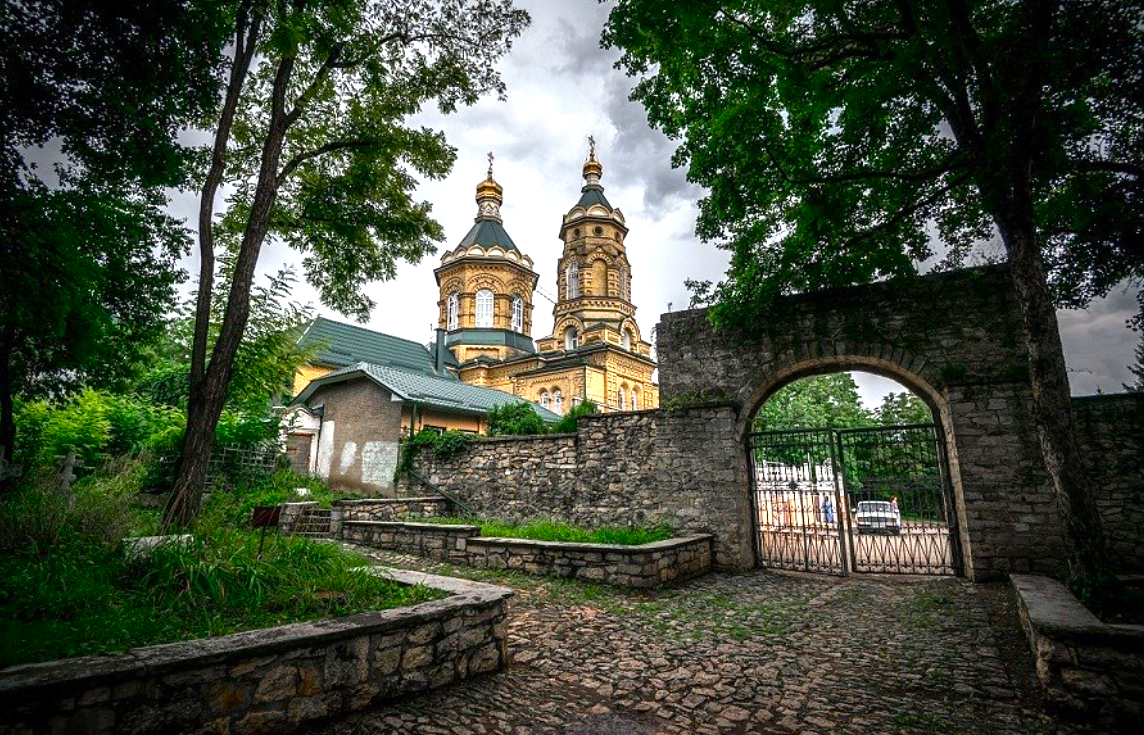 Вид на Лазаревскую церковь с главной аллеи Пятигорского некрополя, которая начинается каменными воротами-аркой. Фото с сайта gidavia.com. Галерея фото