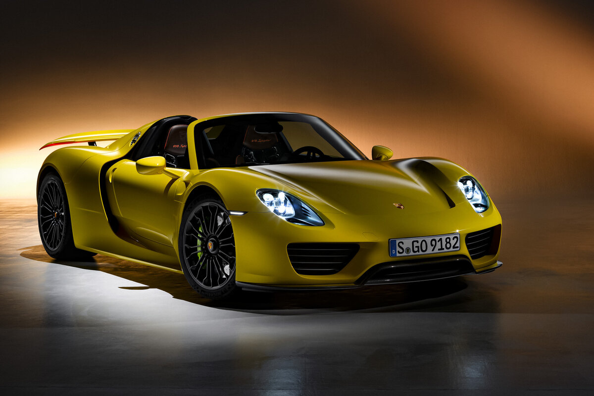    #### Porsche 918 Spyder В 2013 году Porsche, McLaren и Ferrari запустили бензоэлектрические модели, которые олицетворяли вершину инженерной мысли и вошли в историю под красивым понятием «Holy Trinity of Hypercars» («святая троица гиперкаров»). Начнем с реактивного 918 Spyder. Его конструкция испытала сильное влияние гоночной техники. Шасси напоминает анатомию ле-мановских «Порше», а атмосферная V-образная «восьмерка» объемом 4,6 литра базируется на архитектуре прототипа RS Spyder LMP2. В подзаряжаемую от внешнего источника plug-in гибридную систему (в пике — 887 л.с.) включен ДВС, два электромотора (один из них приводит передние колеса) и семиступенчатый преселективный «робот».   
Porsche