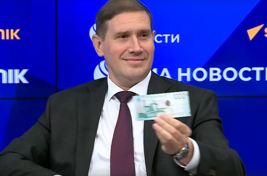 Зам. председателя ЦБ России Сергей Белов демонстрирует новую банкноту в 1000 руб. 2023 г. на пресс-конференции в пресс-центре «Россия сегодня».