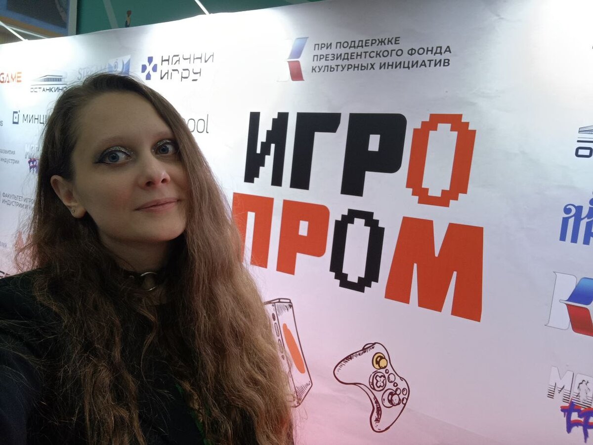 Я на фоне большого стенда с названием фестиваля. Первый день, почти самое начало мероприятия. Немного подкачало освещение всех стендов - оно создавало сильные засветы на баннерах, а людей оставляло в тени. Но это совершенно некритичный недостаток.