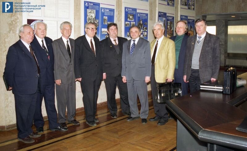 Н.С. Лидоренко, Б.В. Бальмонт, В.И. Севастьянов, В.Ф. Уткин (4-й слева), В.П. Сенкевич, Л.А. Гильдберг, Ю.В. Новиков, В.М. Вишняков, Б.Н. Кантемиров в фойе Академии космонавтики им. К.Э. Циолковского. 29 марта 1999 г. РГАНТД. Арх. № 0-14372 цв.
