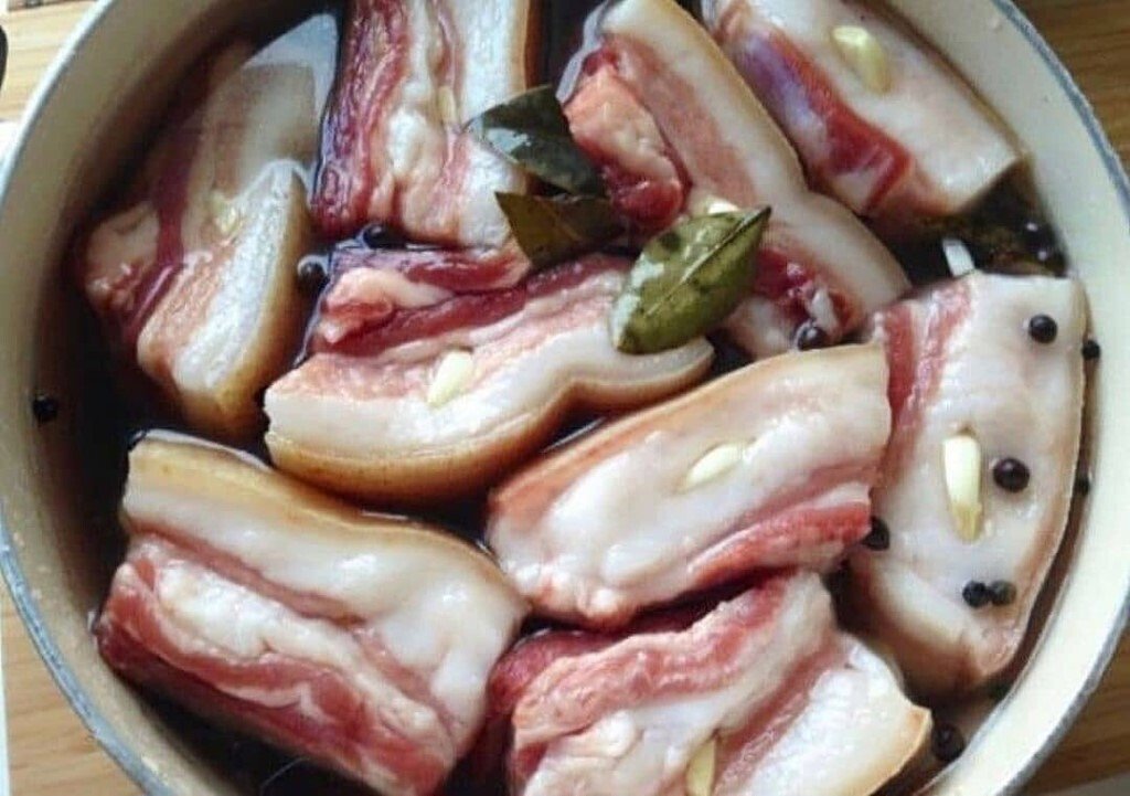 Салом, засолённым в рассоле, никого не удивить, а вот сало в чесночном маринаде-это что-то новенькое! Этот рецепт не очень распространённый и весьма интересный, сало имеет оригинальный вкус и приятное чесночное послевкусие! Таким образом, свежее сало маринуется в холодильнике в крутом рассоле с добавлением лаврового листа, чёрного и душистого перцев, семян горчицы и измельчённого чеснока. Итог потрясающий-сало мягкое, ароматное, полностью просолённое! Для маринования берите небольшие куски сала обязательно с мясной прослойкой (а ещё лучше-прослойками), а в готовом виде подавайте украинский деликатес в качестве закуски, нарезав его тончайшими ломтиками.