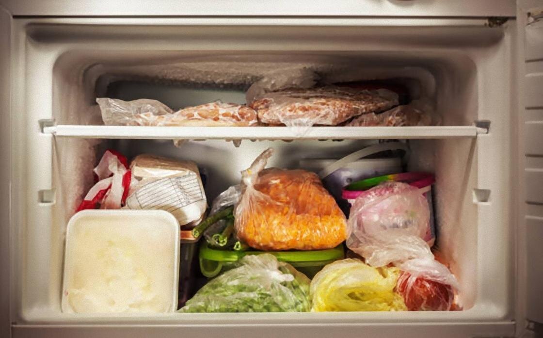    Продукты сложены на полках в открытой морозилке:iStockPhoto