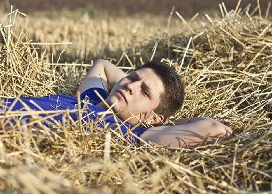 В сене на 1 голову. Парень лежит в поле. Парень на сене. Человек на сеновале. Мужская фотосессия в поле.