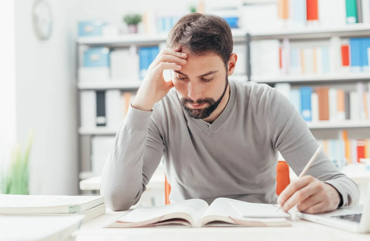 Concentrating on studies. Человек сидит за столом фото. Фото умного человека с ноутбуком. Человек сидит и изучает. Study man.