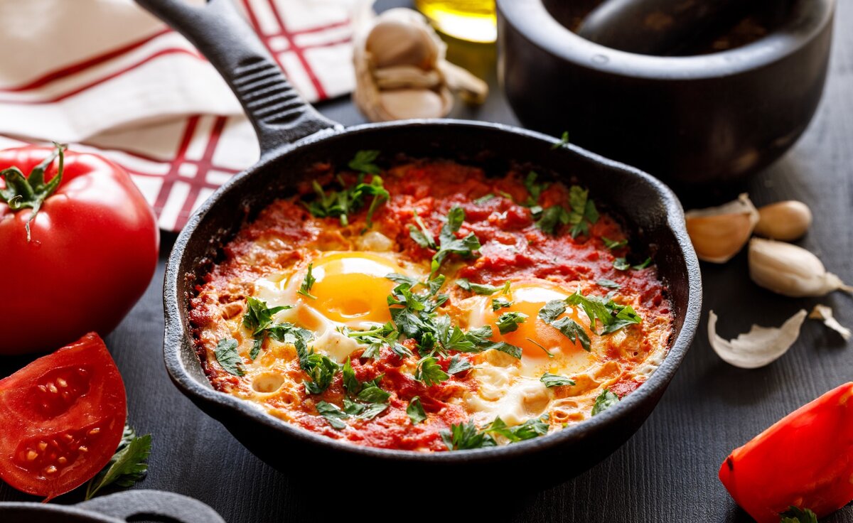 Шакшука - это яичница с овощами и томатом. Подаётся прямо в сковороде.