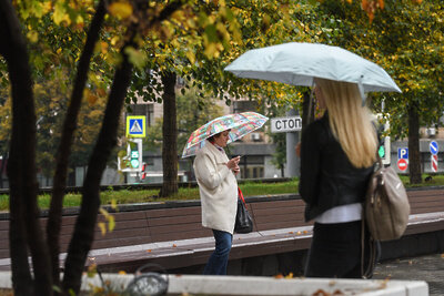    Люди под зонтом без масок осенью в Москве ©Пелагия Тихонова РИАМО