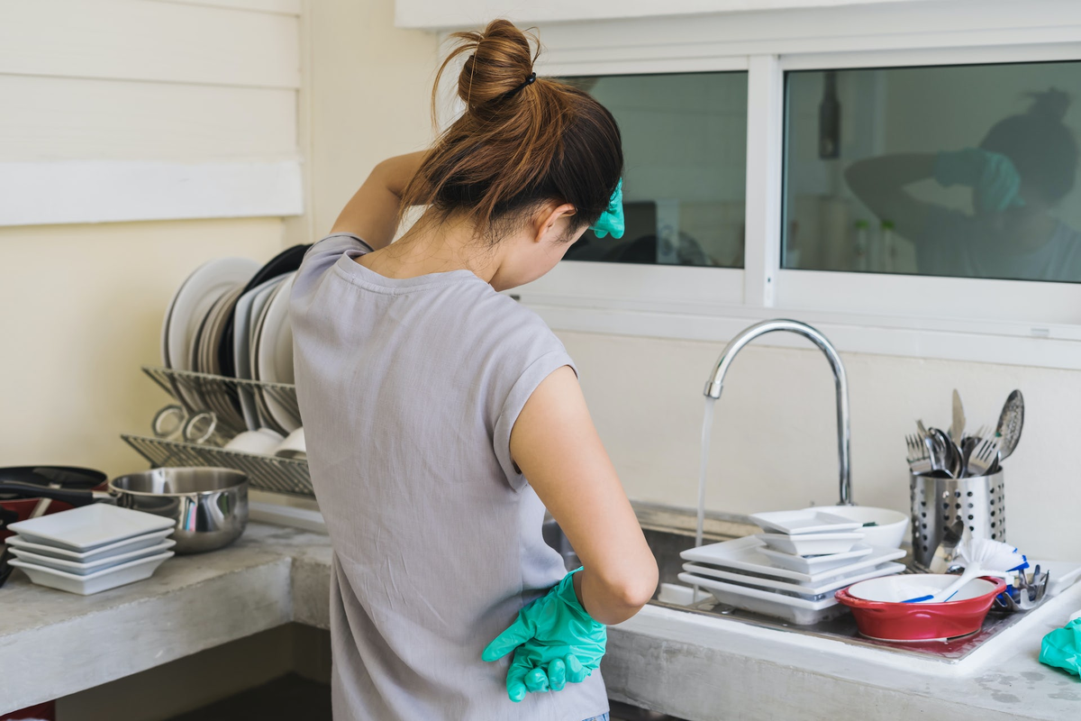 She wash the dishes. Женщина моет посуду в перчатках. Женщина моет посуду устала. Мусульманка моет посуду. Женщина моет посуду со спины.