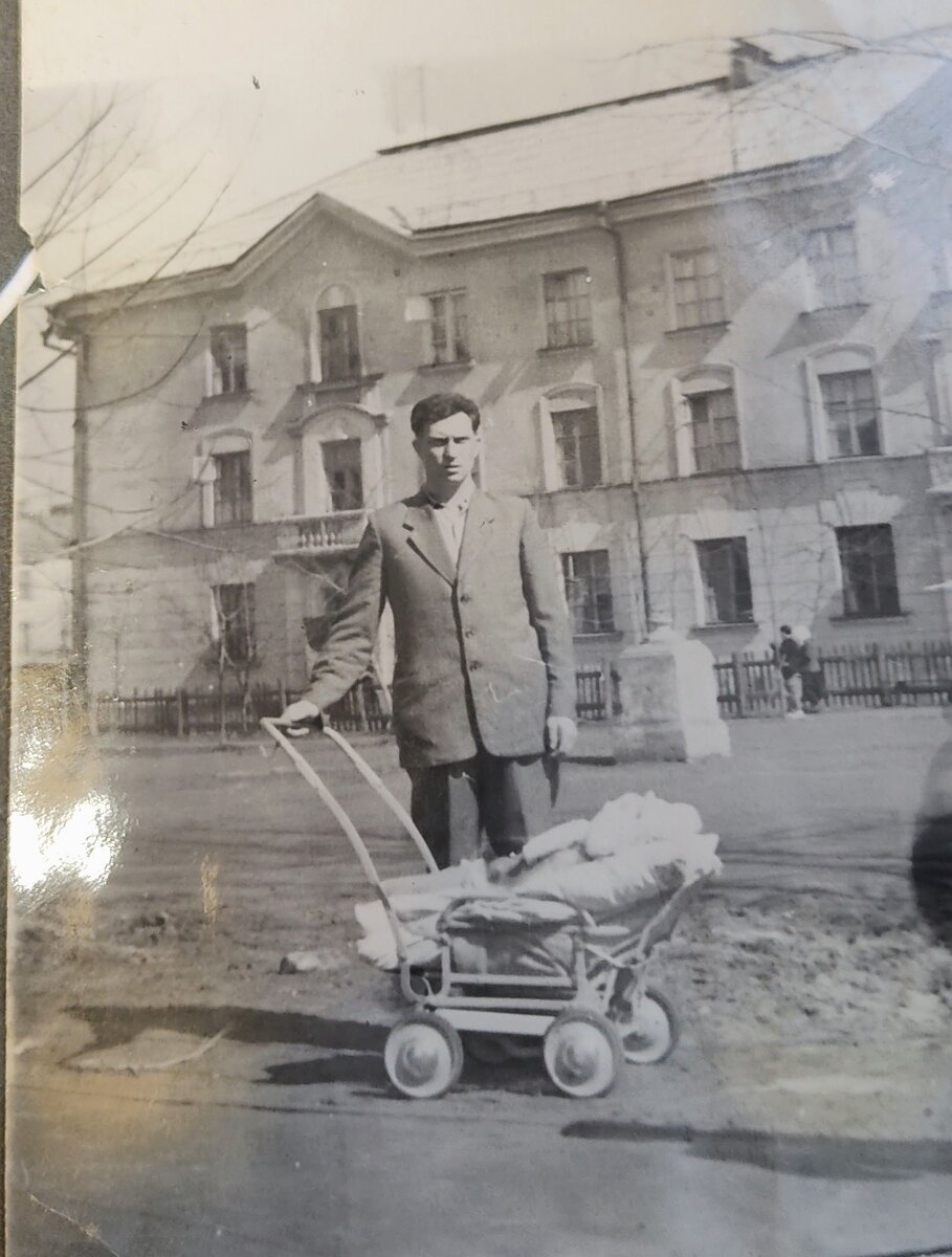 С отцом в родном дворе. Я ещё в колясочке и пока самый единственный и любимый ребёнок